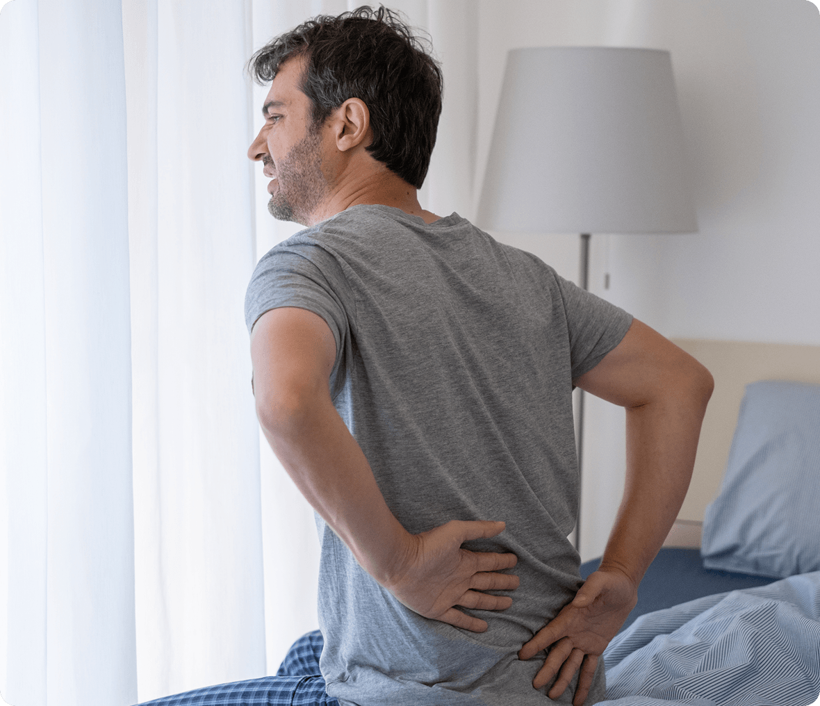Person holding lower back in discomfort