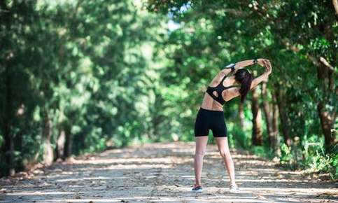 Woman stretching on a forest path