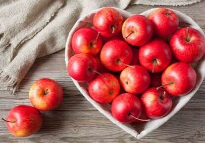 Fresh apples in heart-shaped dish