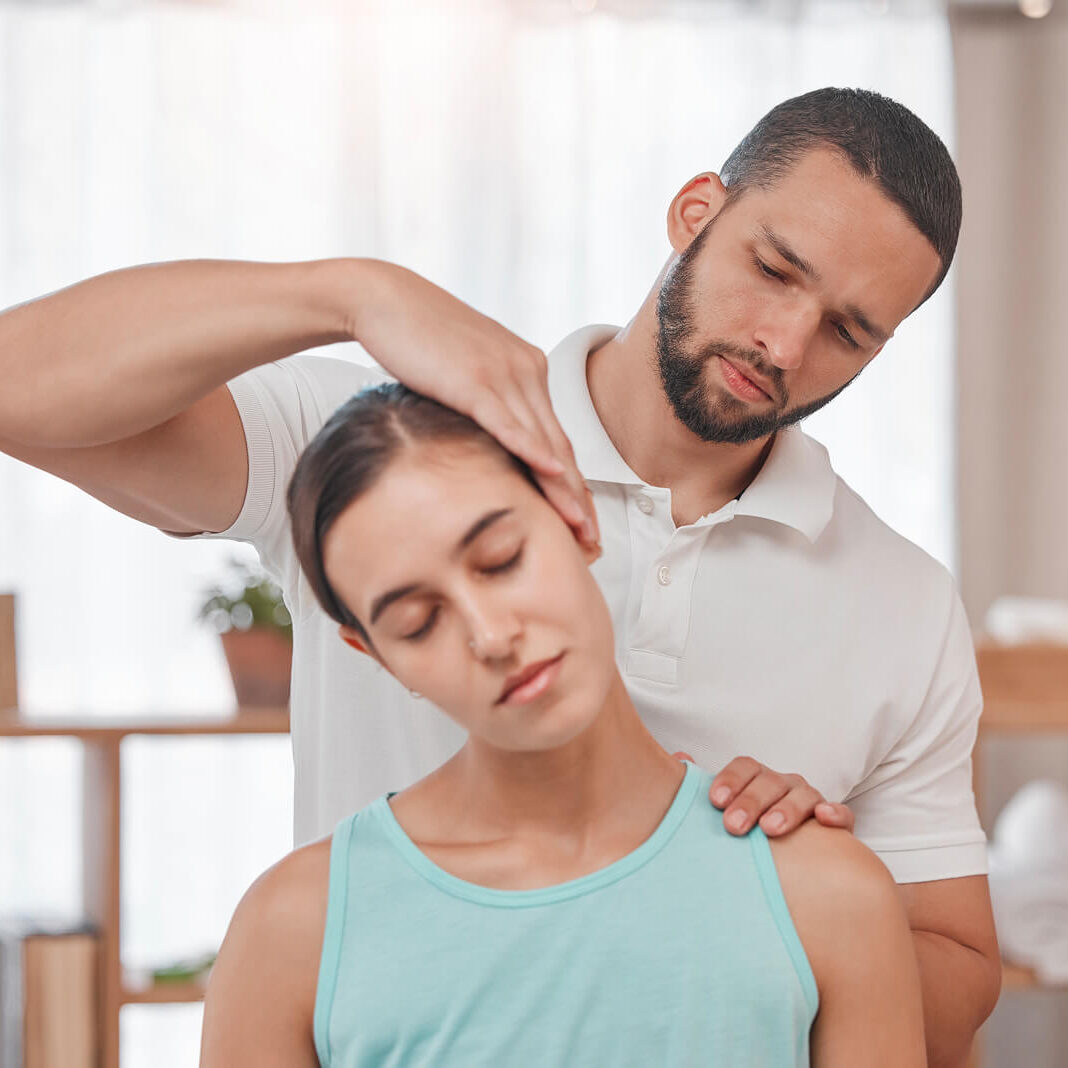 Physical therapist adjusting woman's neck