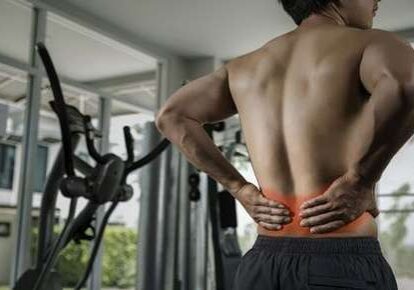 Fitness enthusiast experiencing backache indoors