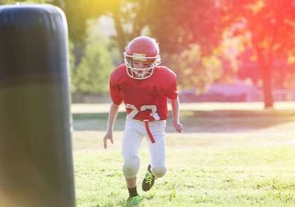 Child wearing football gear running
