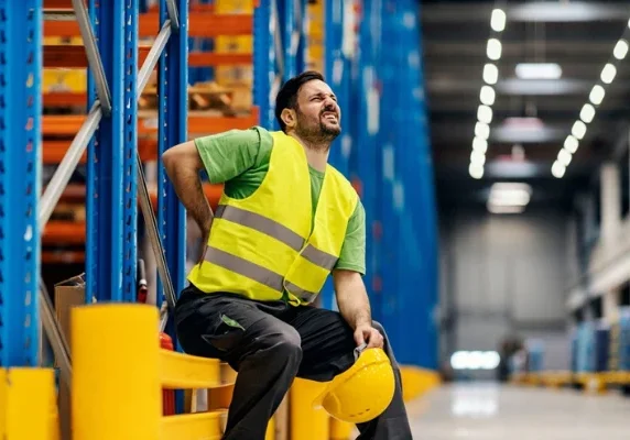 Worker holding back in warehouse