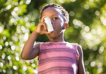 Kid breathing with inhaler in sunlight