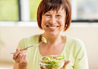 Happy woman with a salad bowl