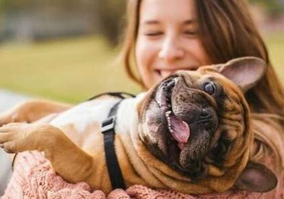 Woman holding happy French bulldog