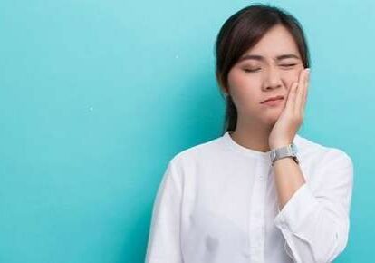 Female in discomfort touching her face