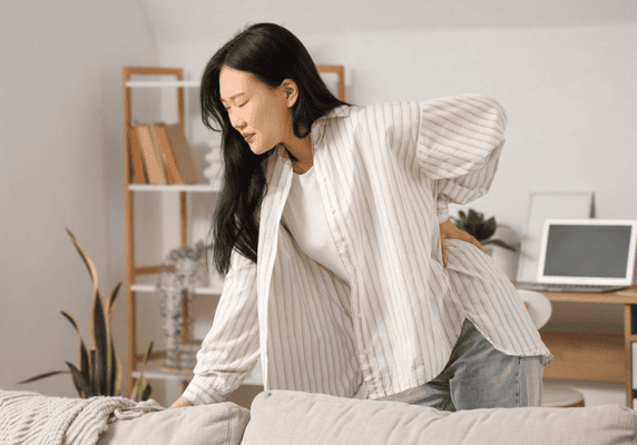 Woman holding her back in discomfort