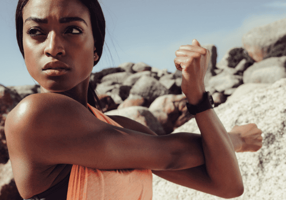 Fitness enthusiast exercising among large rocks