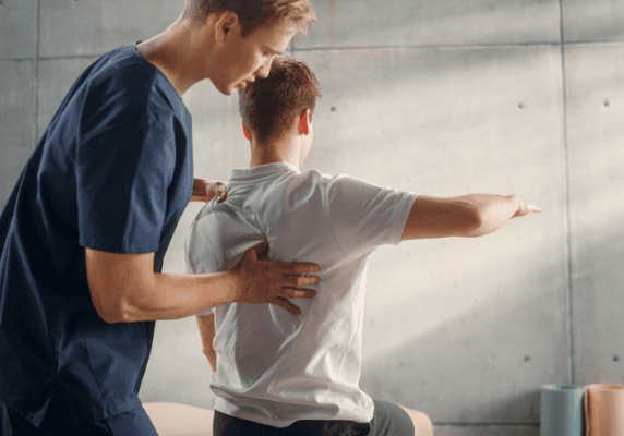Man receiving physical therapy guidance in clinic