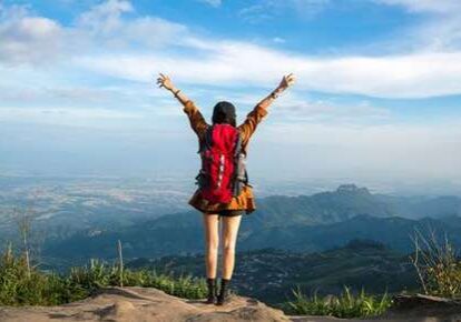 Woman with backpack on cliff