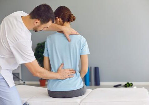 Chiropractor adjusting woman's back