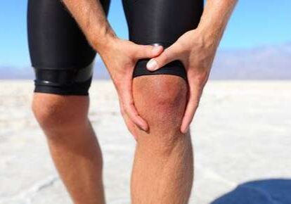 Athlete experiencing knee pain in dry landscape