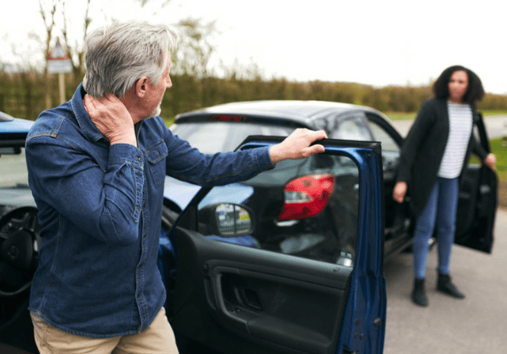 Older man exiting car, woman approaching
