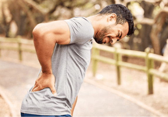 Man experiencing back pain outdoors