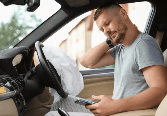 Man in car with airbag deployed