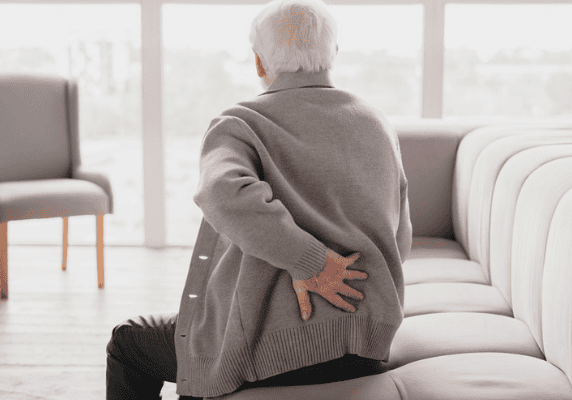 Man experiencing backache while seated.