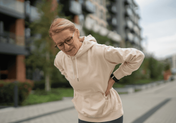 Woman in hoodie with back discomfort