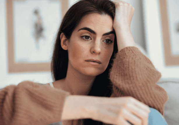 Contemplative expression on woman's face at home
