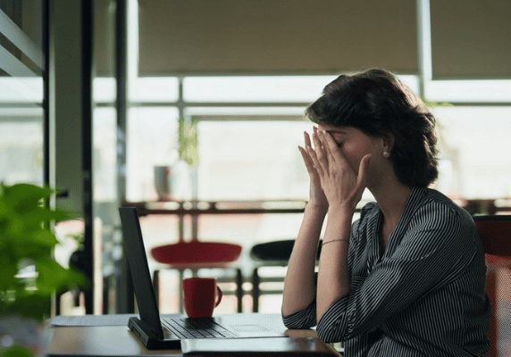 Woman overwhelmed at computer table