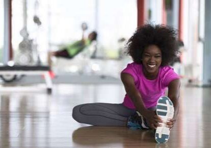 Smiling woman doing a seated stretch