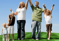 Family holding hands on grassy hill