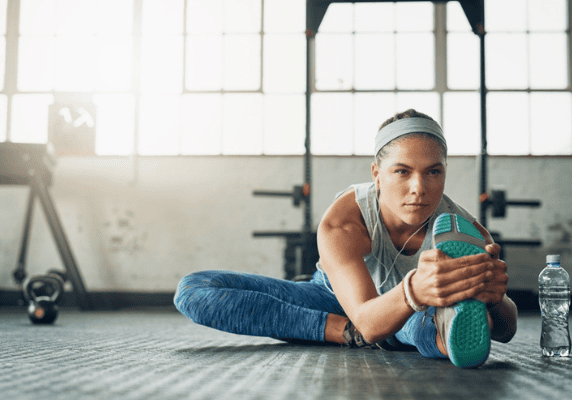Athlete doing floor stretches in sunlight