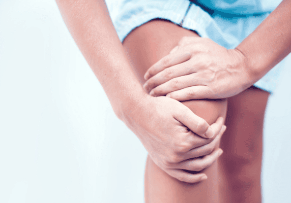 Hands gripping a sore knee