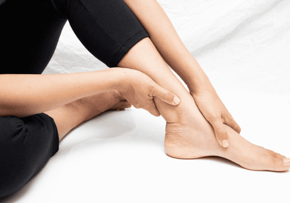 Relaxed seated pose with ankle held gently.