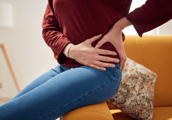 Woman holding hip in discomfort