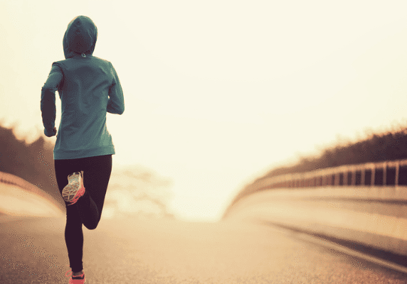 Jogger in blue hoodie at sunrise