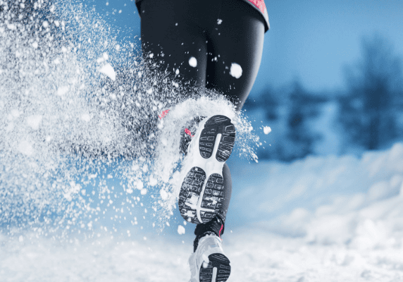Runner's feet kicking up snow