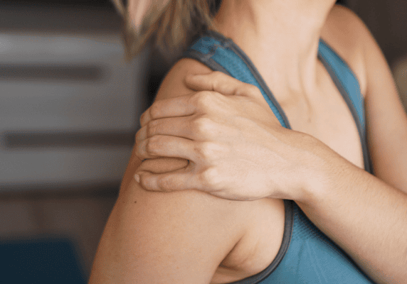 Woman holding her shoulder in pain