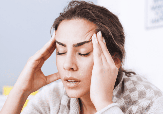 Female experiencing tension headache indoors