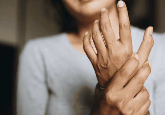 Person holding wrist in discomfort