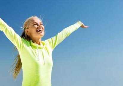 Joyful woman with arms raised outdoors