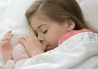 Sleeping child cuddling a toy